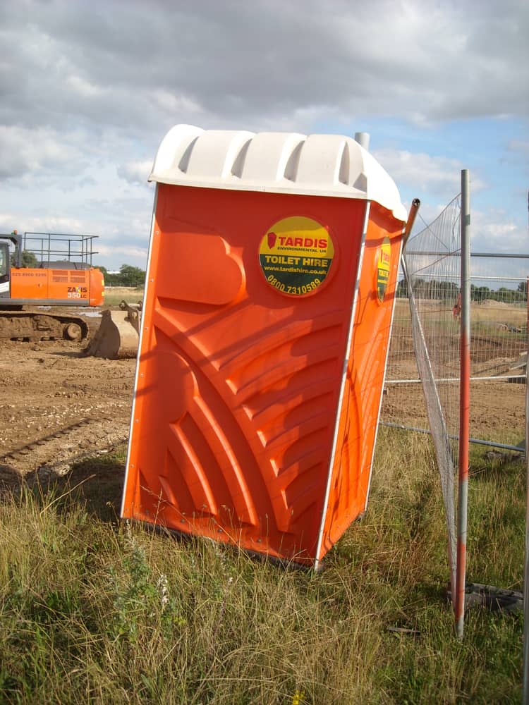 Event portable restroom cluster in Coon Rapids, MN: a hired portable restroom in place on an active construction site