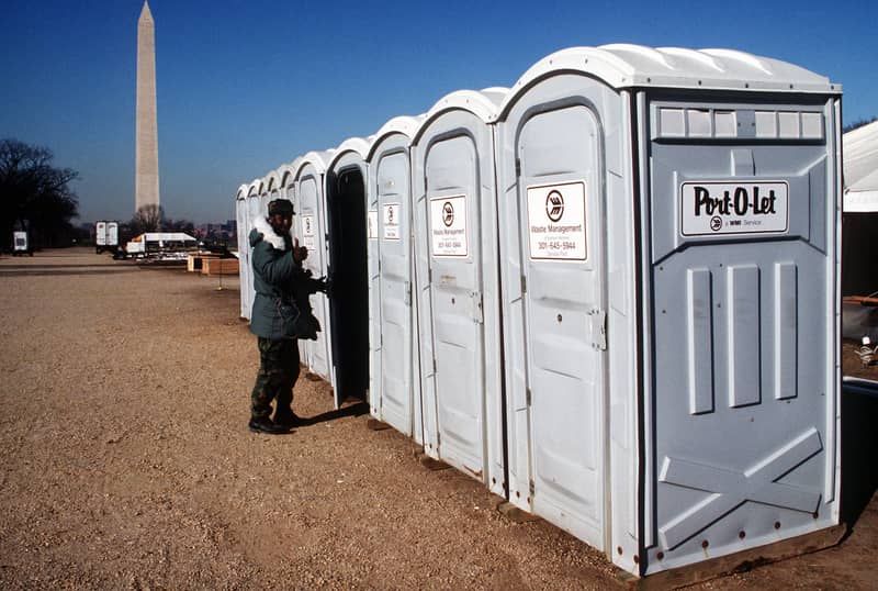 An accessible portable restroom placed at the end of a row beside standard units, the standard cluster arrangement for a Minnesota public event